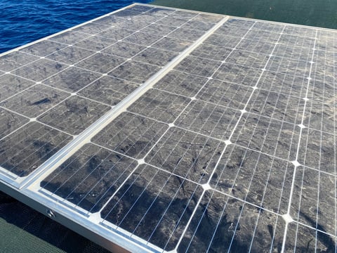 Low angle view and close-up of dusty solar panel.